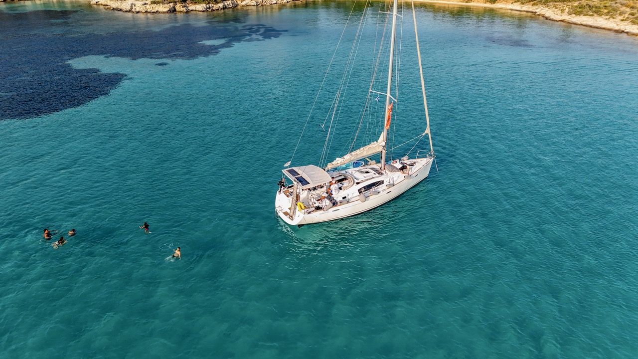 Full day sailing cruise Halkidiki — sailing yacht anchored in a secluded bay with guests swimming